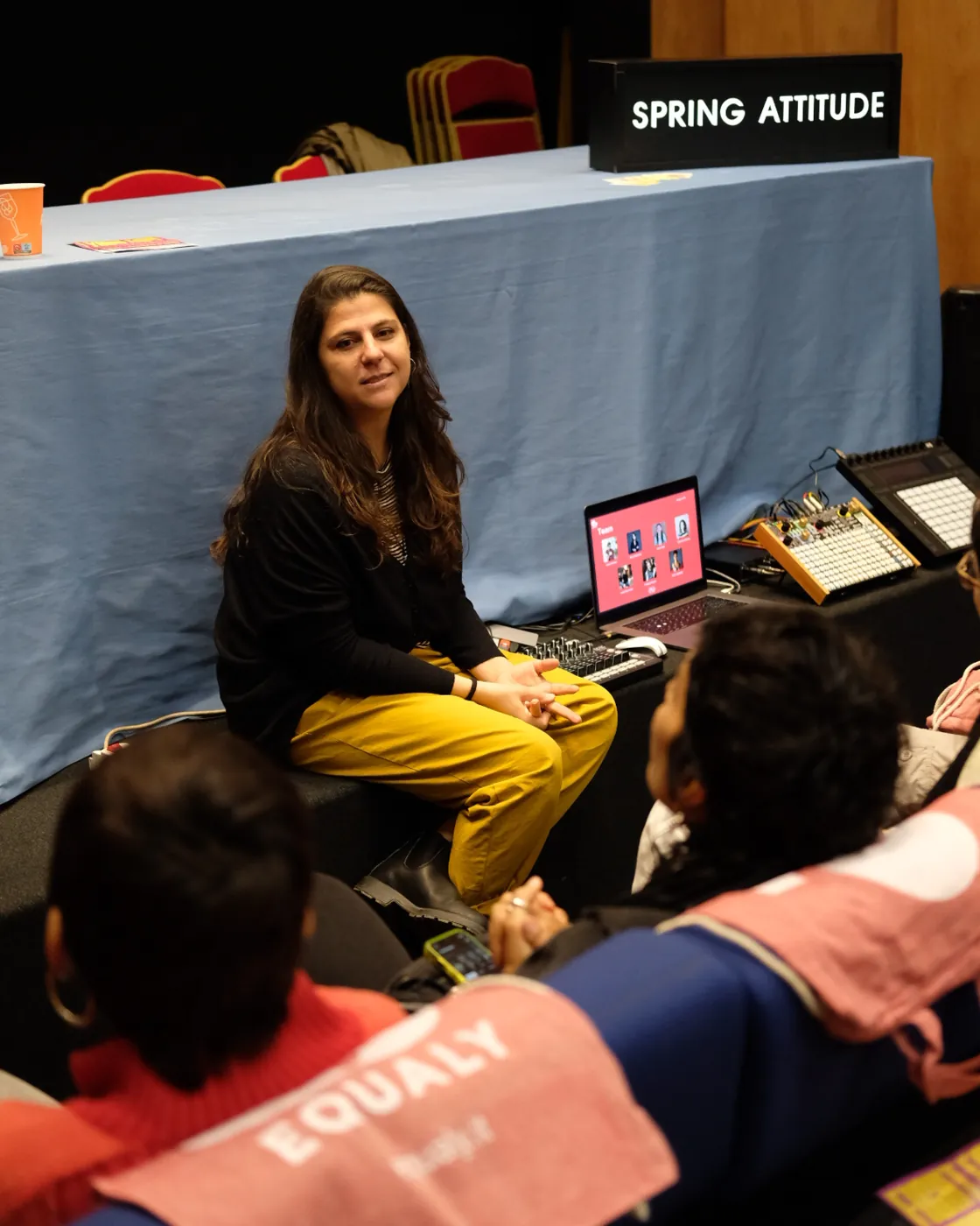Una mentor parla con le partecipanti, in primo piano una borsa Equaly