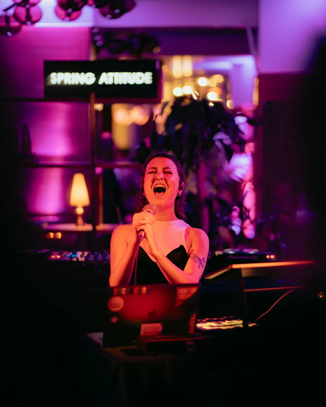 Un'artista canta a occhi chiusi davanti all'insegna Spring Attitude