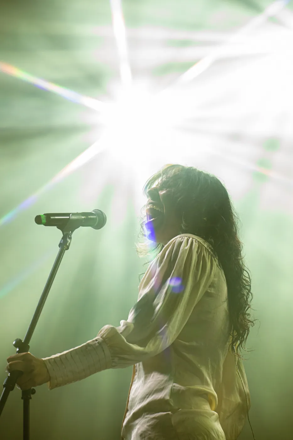 Una cantante in controluce al microfono